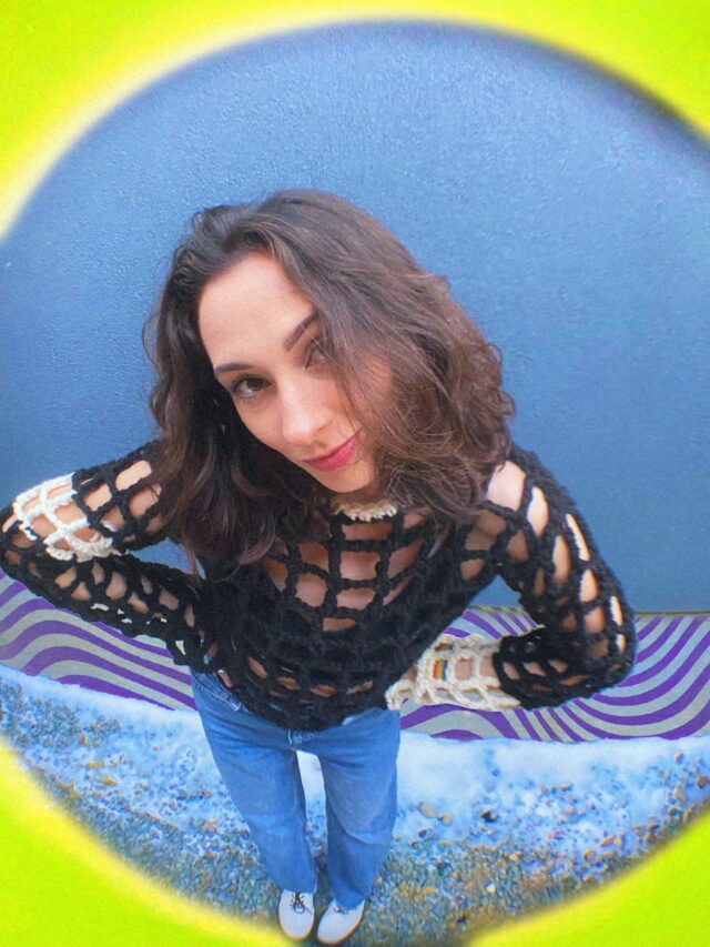 a woman standing in front of a blue wall